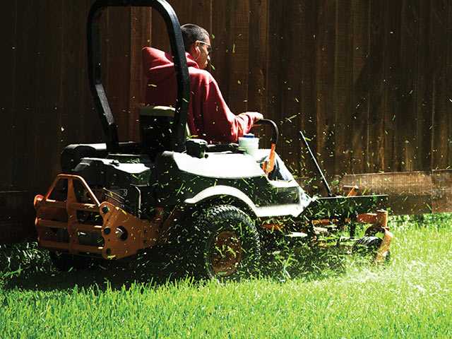 exteriors man mowing lawn on tractor